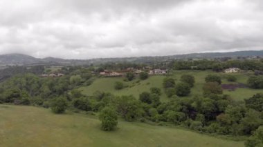 Yeşil tepeler, çayırlar ve ormanlarla kırsal alanın panoramik havadan çekimi