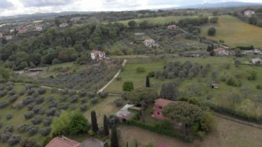 Zeytin ağaçları ve ormanlar ve muhteşem bulutlu gökyüzü ile yeşil çayırları ile vadi üzerinde İtalyan kırsal Drone havadan görünümü