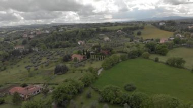 Dramatik bir gökyüzünde yeşil çayırlar ve ormanlar üzerinde İtalyan kırsal Manzara drone görünümü
