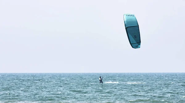 Atleta realiza kitesurf entre ondas e espuma em um d ideal — Fotografia de Stock