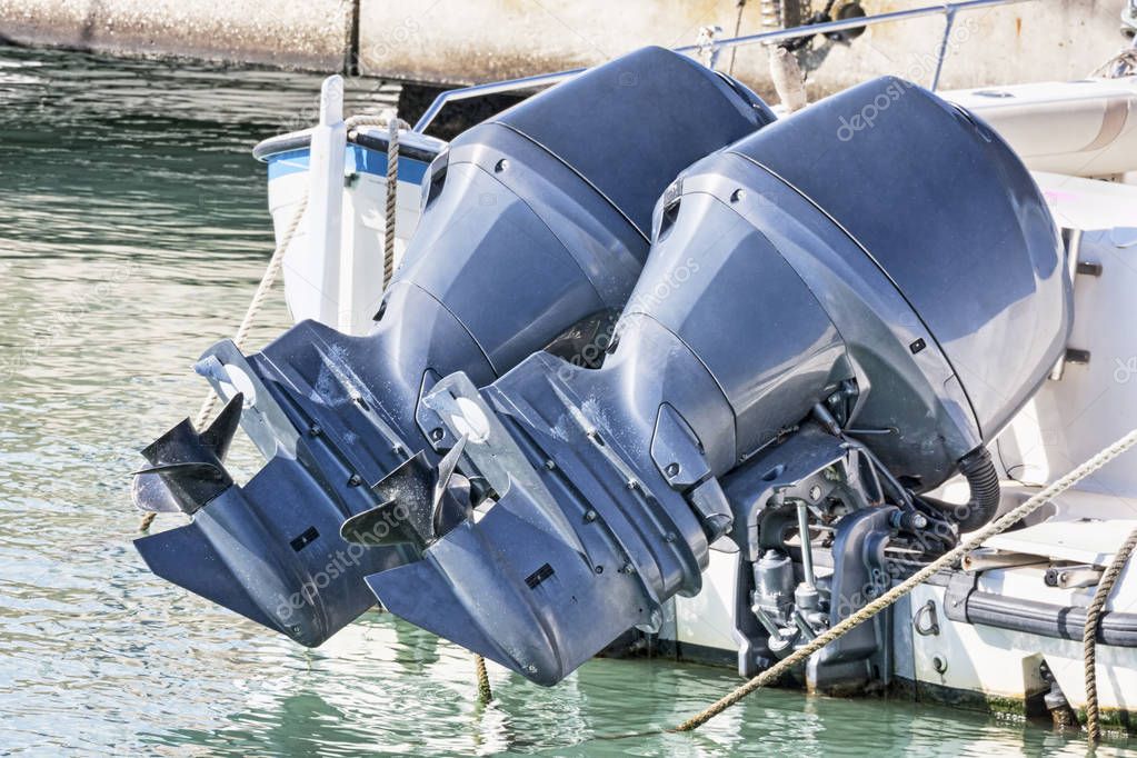 Couple of used blue outboard engines mounted on a speedboat