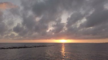 Ostia Lido'da güzel renk ve dramatik gökyüzü ile denizde rahatlatıcı gün batımı