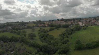 Muhteşem bir gökyüzü ile İtalya tepeler arasında tepelik ormanlar ve yeşil çayırların havadan görünümü