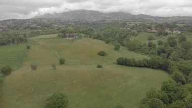Dramatik bir gökyüzünde tepeler ve köy silueti arasında kırsal yerleşim ile meşe ormanları ve yeşil vadi ile İtalya kırsal üzerinde Awesome panoramik hava görünümü