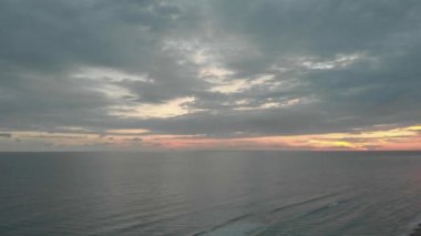 Dramatik ışık ve müthiş bulutlu gökyüzü ile okyanus üzerinde uzak gün batımı uçuş