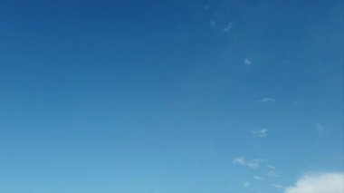 İyi bir hava gününde beyaz cirrus bulutları ile açık gökyüzü ve mavi renkli arka plan ile zaman atlama