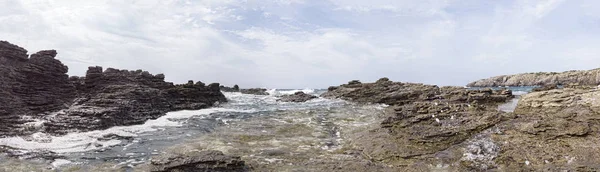 Dalgalı denizler, rüzgarın yonttuğu kayaların üzerinde kırılır ve manzaralı bir manzara oluşturur. — Stok fotoğraf