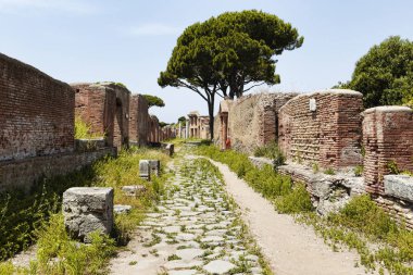 Roma İmparatorluğu Köy Manzarası ve Ostia Antica 'nın arkeolojik kazılarında kaldırım taşı yolları, apartmanlar ve antik dükkan kalıntıları, Roma İtalya