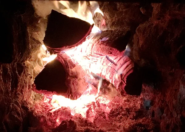 Beautiful red flame from slice wood, dark grey black coals inside metal brazier. Wood burning in the brazier on bright yellow flame. Flames fire preparation for cooking barbecue. Brazier on fires coal