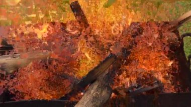 Dilimlenmiş tahtadan çıkan güzel kırmızı ateş, metal brazier 'ın içinde koyu gri siyah kömür. Parlak sarı ateşte, brazier 'da odun yanıyor. Alevler barbekü pişirmeye hazırlanıyor. Brazier doğa bbq üzerine.