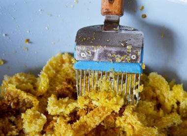 Altın nektarla doldurulmuş altıgen bal peteklerinden bir damla bal damlıyor. Bal peteği yaz kompozisyonu. Doğal bal damlası, balmumu çerçeveli arı damlası. Bal damlası bal damlatıyor bal peteğine.