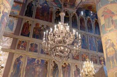 Çok güzel dizayn edilmiş bir avize göz kamaştırıcı dini duvar resimleriyle süslenmiş muhteşem bir kilise aydınlatıyor.