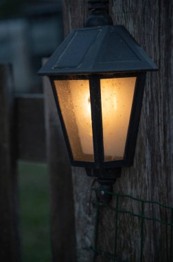 Hoş bir gece sahnesinin huzurlu atmosferini zenginleştiren, sıcak ve davetkar bir parıltı saçan büyüleyici bir fener.