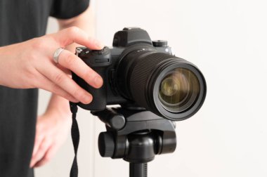 Stüdyoda bir tripodun üstündeki profesyonel bir kamera, yaratıcılığa ilham veren fotoğraf malzemeleri sergiliyor.