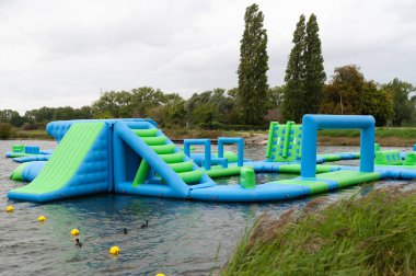 A vibrant and colorful inflatable water park featuring a variety of challenging obstacles for summer enjoyment and fun