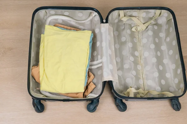 A neatly packed suitcase filled with colorful folded clothing, ideal for inspiring your next travel adventure