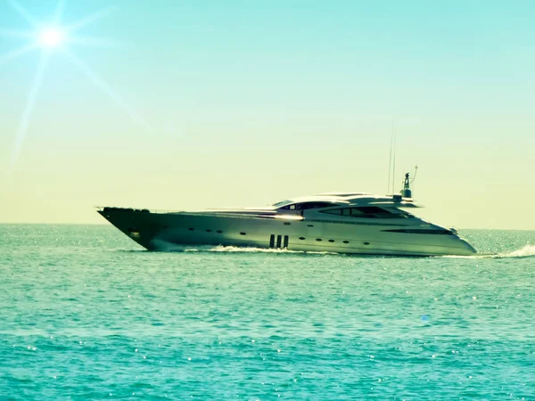 Ocean yacht in the sun - high-speed marine yacht cuts through the waves