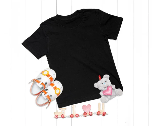 Black kids t-shirt with sandals and toys on white background - romantic mockup for your design