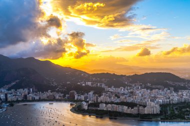 Sahil ve deniz araçları ile şehir üzerinde dramatik günbatımı