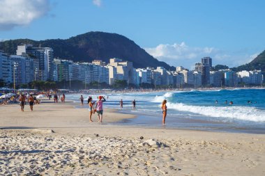 Sahil gün batımında, deniz kenarında yürüyüş insanlar
