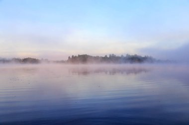 Nehir mavi gökyüzü arka plan karşı ihale sisli gün batımında