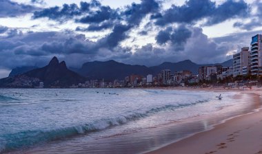 Sahil gün batımında, deniz kenarında yürüyüş insanlar