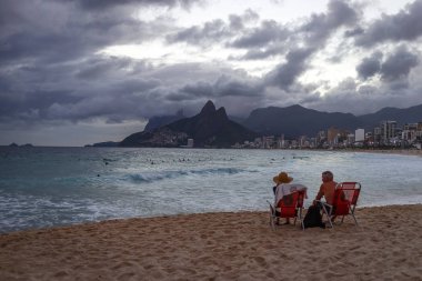 Sahil, sandalyelere akşam dinlenme turist çiftin arkadan görünüş