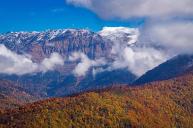 Mavi gökyüzü arka plan üzerinde beyaz bulutlar ve sonbahar dağlar havadan görünümü