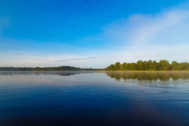 Sakin nehir, ağaçlar ve mavi gökyüzü arka plan manzara