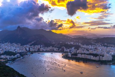 Sahil ve deniz araçları ile şehir üzerinde dramatik günbatımı