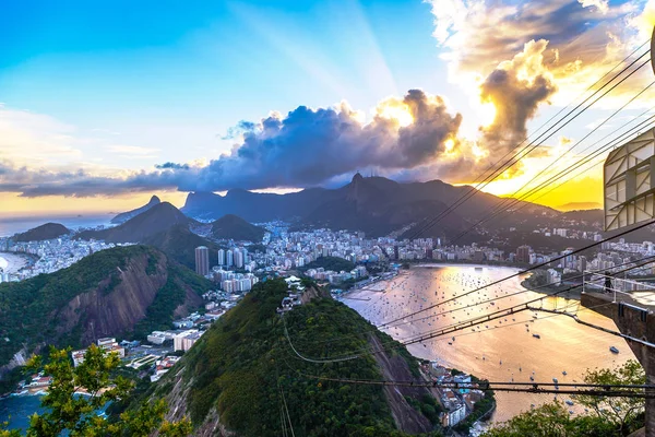 Deniz ve bulutlu gökyüzü ile şehrin üzerinde dramatik günbatımı