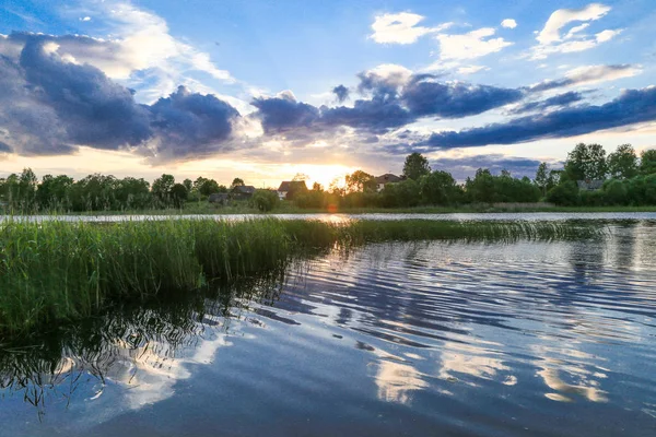 Dramatik bulutlu gün batımında riverside yaz aylarında 