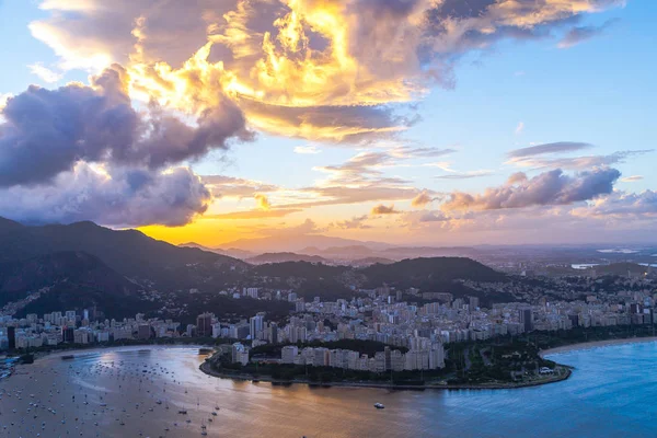 Sahil ve deniz araçları ile şehir üzerinde dramatik günbatımı