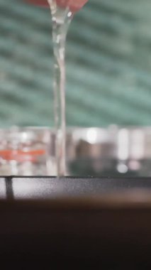 Bir el yumurtayı nazikçe kırar, yumurta sarısı ve beyazın cızırdayan bir tavaya düşmesine izin verir. Mutfak aydınlık ve düzenli, güzel bir yemek ortamı yaratıyor..