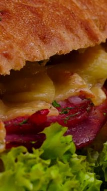 Bu lezzetli sandviçte yapışkan peynir katmanları, taze yeşiller ve lezzetli etler var. Hepsi sıcak ve davetkar bir mutfak ortamında hazırlanmış..