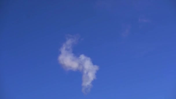 Дым выходит из дымохода на фоне голубого неба — стоковое видео