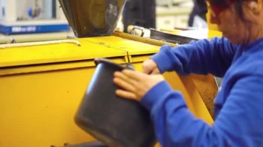 Fabrika işçisi granulate işleme makine içine dökülen. Windows dönüştürülebilir malzemeden üretilen plastik imalatı. Fabrika plastik pencere.