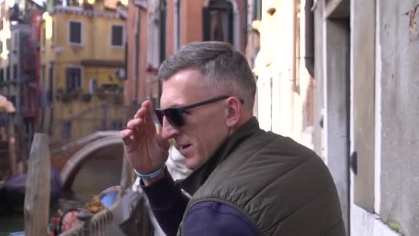 Dreht sich der Mann um und nimmt seine Brille ab — Stockvideo