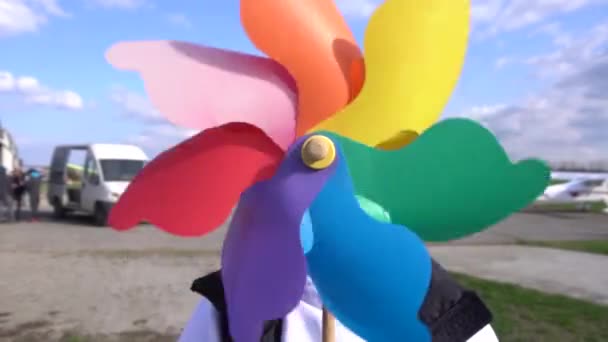 Rainbow färgad spinning vindsnurror på gräs — Stockvideo