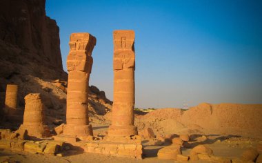last standing pillars of Napata's temple of Amun at the foot of Jebel Barkal mountain , Karima, Sudan clipart