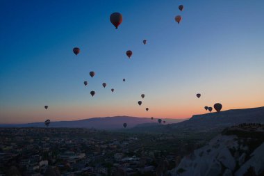 Göreme şehrine ve uçan balonlara gün doğumu panoramik manzarası, Kapadokya, Türkiye