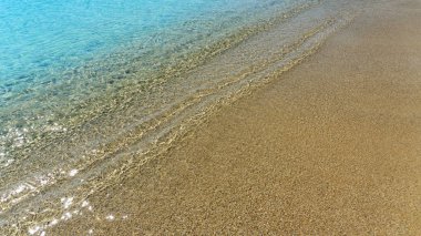 Sarı kum ve turkuaz deniz. Yakın çekim. En az