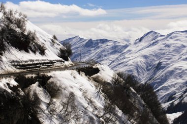 Kışın dağ yolu. Dağ sıralarının arasında derin gorge. Kafkasya karla kaplı tepeler