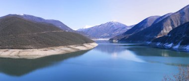 Mavi göl dağ silsilesi karlı dorukları karşı dağlarda. Açık güneşli bir gün, pürüzsüz yüzey su iyi havalarda. Gürcistan Seyahat. Panorama