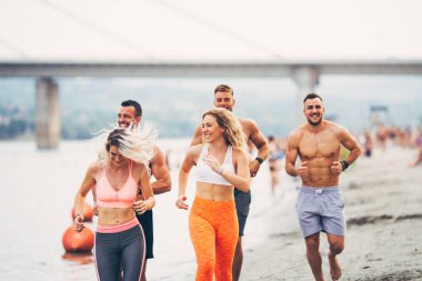 Genç çekici insanlar fitness egzersiz grubudur. Onlar eğleniyor ve plajda çalışan.