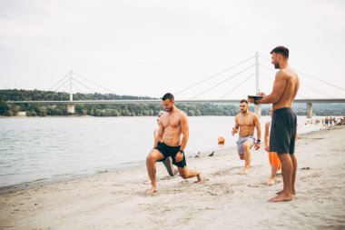 Grup Genç çekici insanlar plajda eğlenmek ve bazı fitness egzersiz yapıyor.