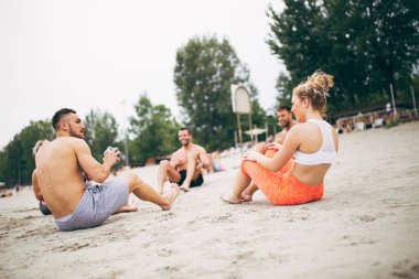 Grup Genç çekici insanlar plajda eğlenmek ve bazı fitness egzersiz yapıyor.