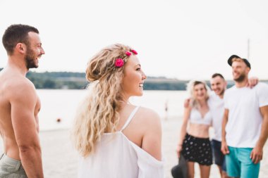 Gençlerin grup plajda piknik üzerinde zevk çekici