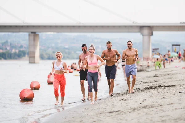 Группа Молодых Привлекательных Людей Фитнес Тренировки Веселятся Бегают Пляже — стоковое фото