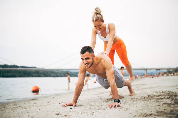 Group young attractive people having fun on beach and doing some fitness workout.